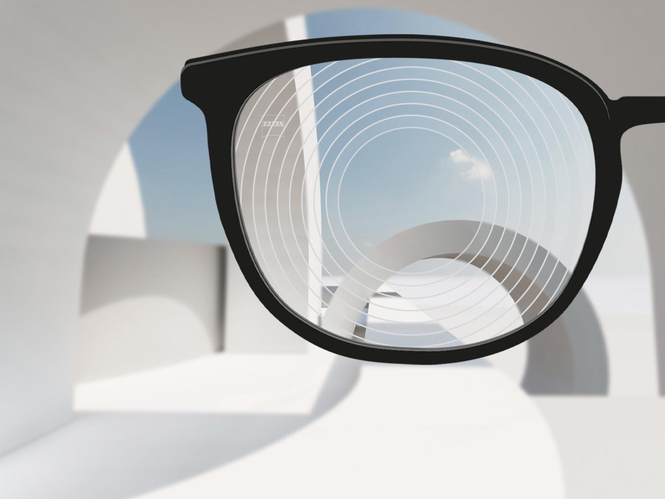 Imagen en primer plano de los lentes de control de la miopía de ZEISS, con montura de gafas negra y círculos concéntricos en la superficie del lente.