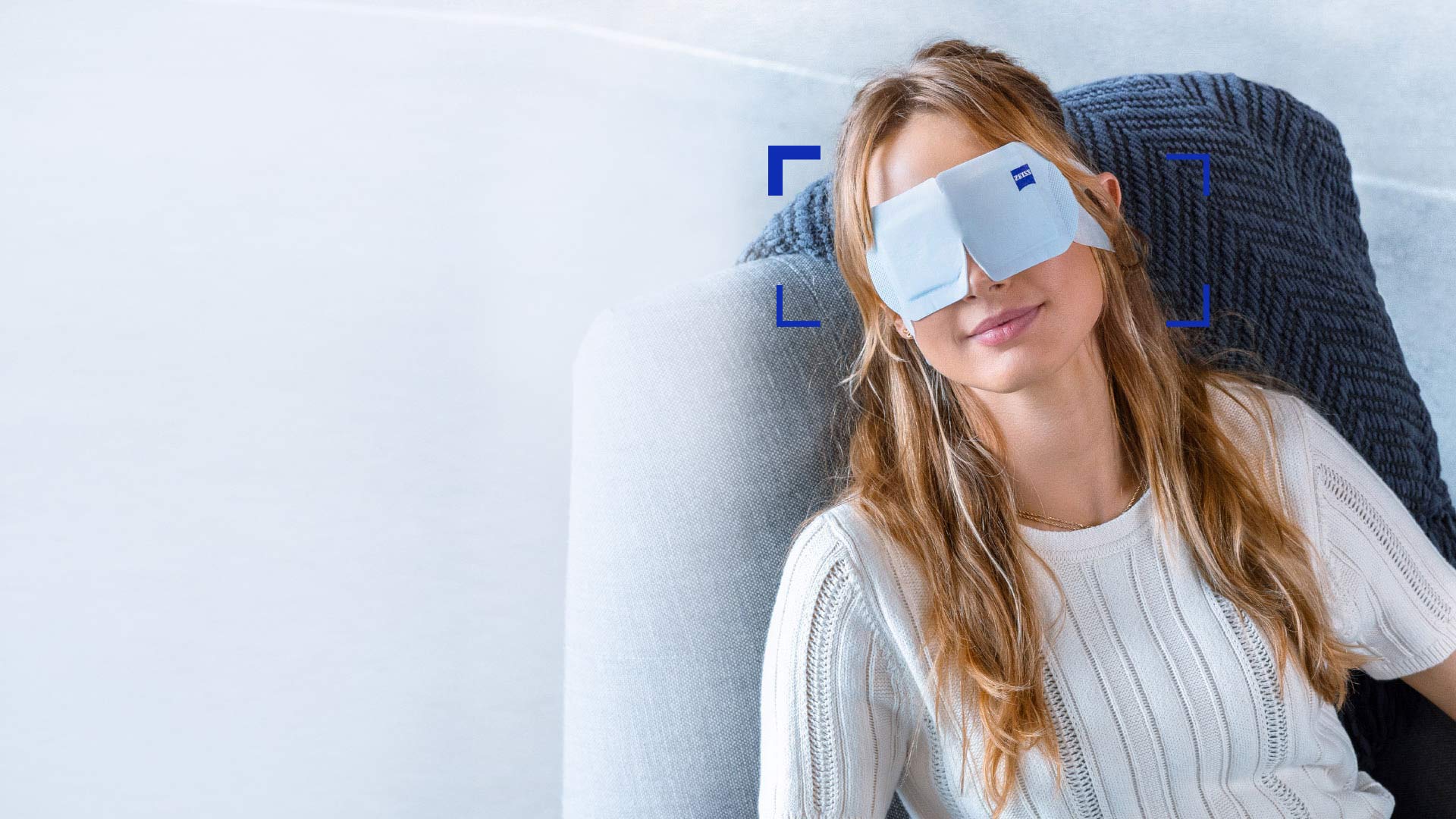 Mujer que usa una ZEISS Warm Eye Mask y se la ve relajada en una silla.