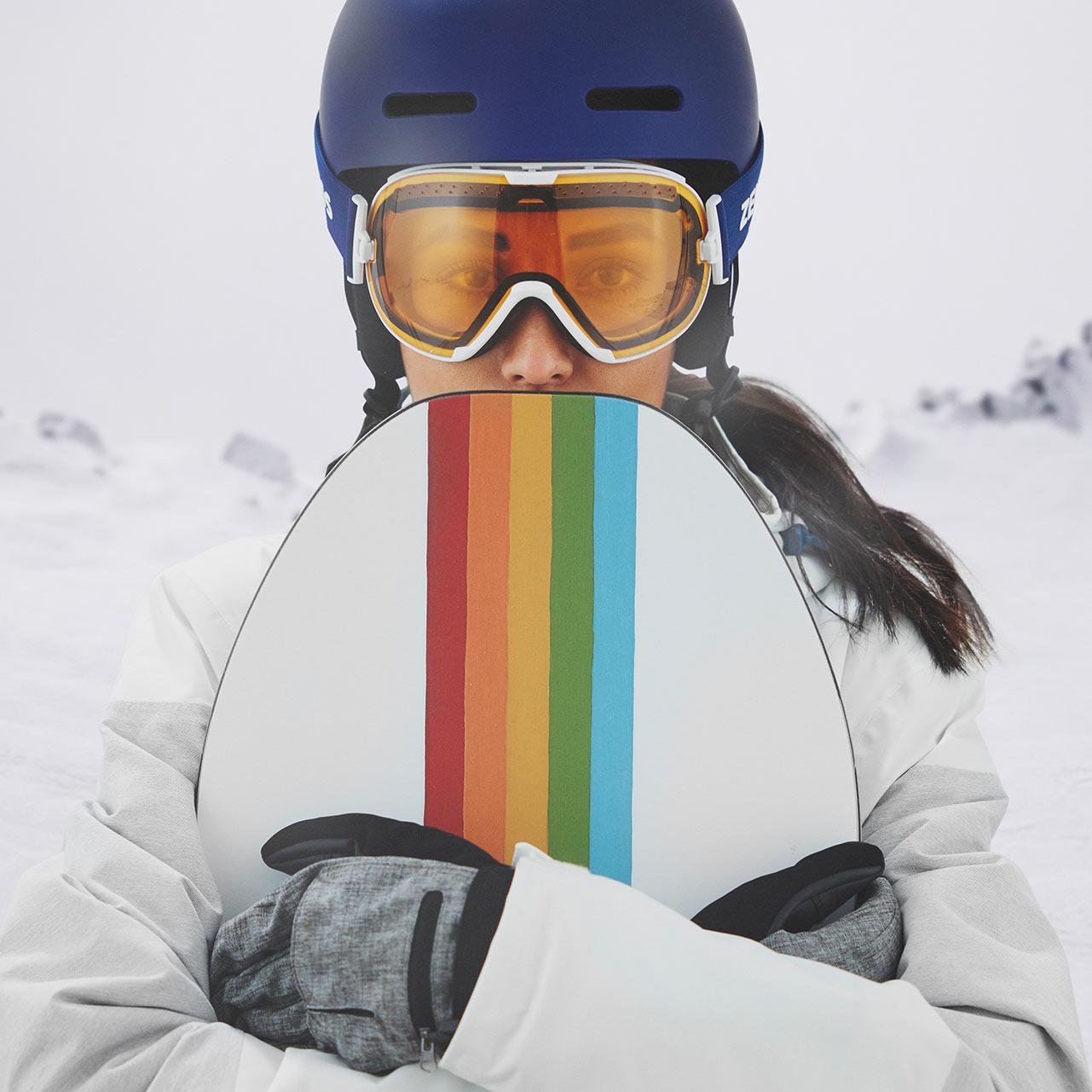 Una mujer porta un casco azul y unas máscaras de esquí ZEISS con visera transparente.