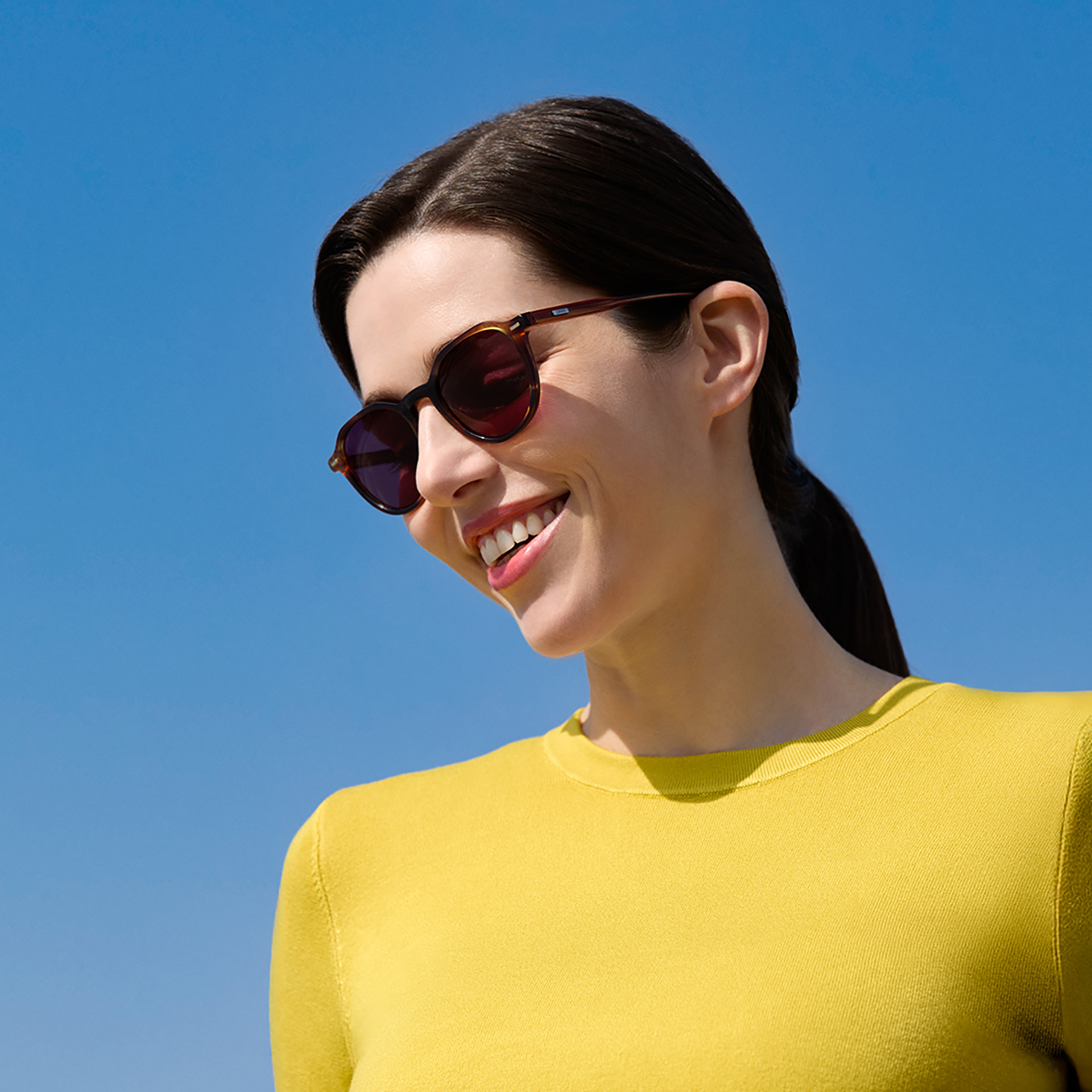 Mujer con lentes solares con prescripción de ZEISS en color Burgundy. 