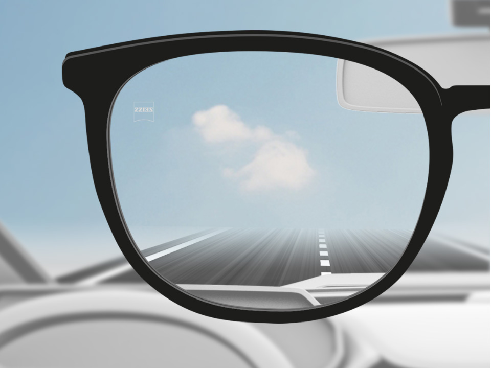 Imagen de un punto de vista de un conductor de automóvil con lentes de visión sencilla ZEISS DriveSafe, y desde el lente se ve totalmente nítido. 