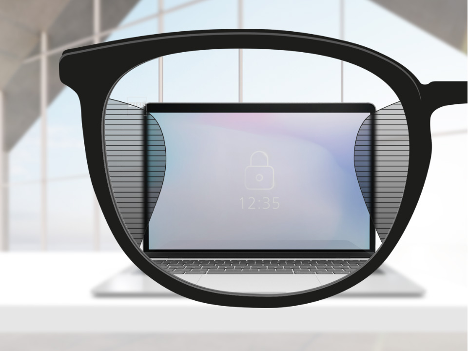 Imagen de un punto de vista con lentes ZEISS Office con una pantalla de computador en el centro del lente y zonas borrosas a izquierda y derecha.